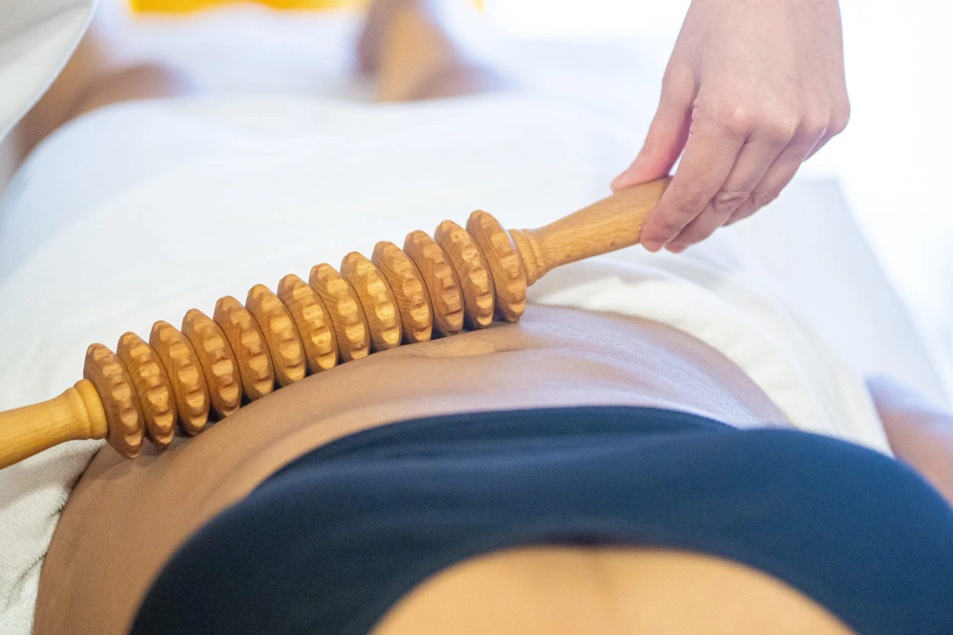 Rodillo de maderoterapia sobre el abdomen